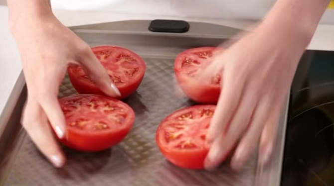 Elle dispose les tomates sur une plaque, ajoute quelques ingrédients et obtient un plat délicieux.